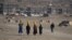 Kuchi women carry water on their heads on the outskirts of Kabul in late November.