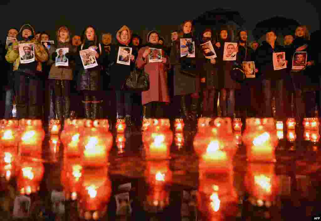 Participants hold portraits of people who were killed during the Euromaidan protests in 2014 during a ceremony in the western city of Lviv to mark the second anniversary of the bloodiest day of the antigovernment protest on February 19. (AFP/Yuriy Dyachyshyn)