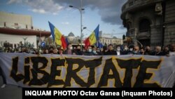 În Piața Univeristății, protestatarii au un banner pe care scrie „Libertate”