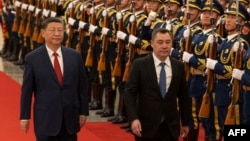 Президент Китаю Сі Цзіньпін (ліворуч) і президент Киргизстану Садир Жапаров проходять повз почесну варту під час церемонії в Пекіні у лютому 2025 року