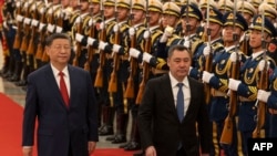 Chinese President Xi Jinping (left) and Kyrgyzstan's Sadyr Japarov pass an honor guard during a Beijing ceremony in February 2025.