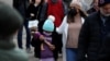 Anya és lánya arcmaszkban sétál Manhattanben 2021. december 6-án, miután Bill de Blasio New York-i polgármester bejelentette, hogy a magánszektor munkavállalói számára is kötelezővé kell tenni az oltást az omikron terjedése miatt