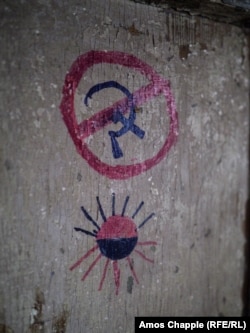 Graffiti on the door of a frontline position in the Luhansk region. The sun at the bottom is made in the colors of the Ukrainian Insurgent Army, a World War II-era militant group responsible for the mass killings of ethnic Poles and others in western Ukraine in 1943.