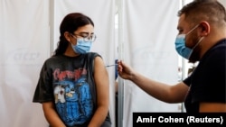 Žena u Tel Avivu prima dodatnu dozu vakcine protiv korona virusa. 