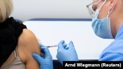 Një grua duke u vaksinuar kundër COVID-19 në Zvicër.