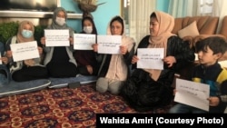 Women protest inside a private home on October 30. The protests are part of a campaign by women activists to press the Taliban for their right to work, get an education, and participate in public life.  