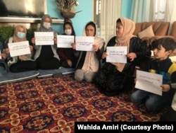 Women hold a protest against Taliban rule inside a private home in Kabul in October, part of a campaign by female activists to press the Taliban for their rights to work, education, and full participation in the government and society.