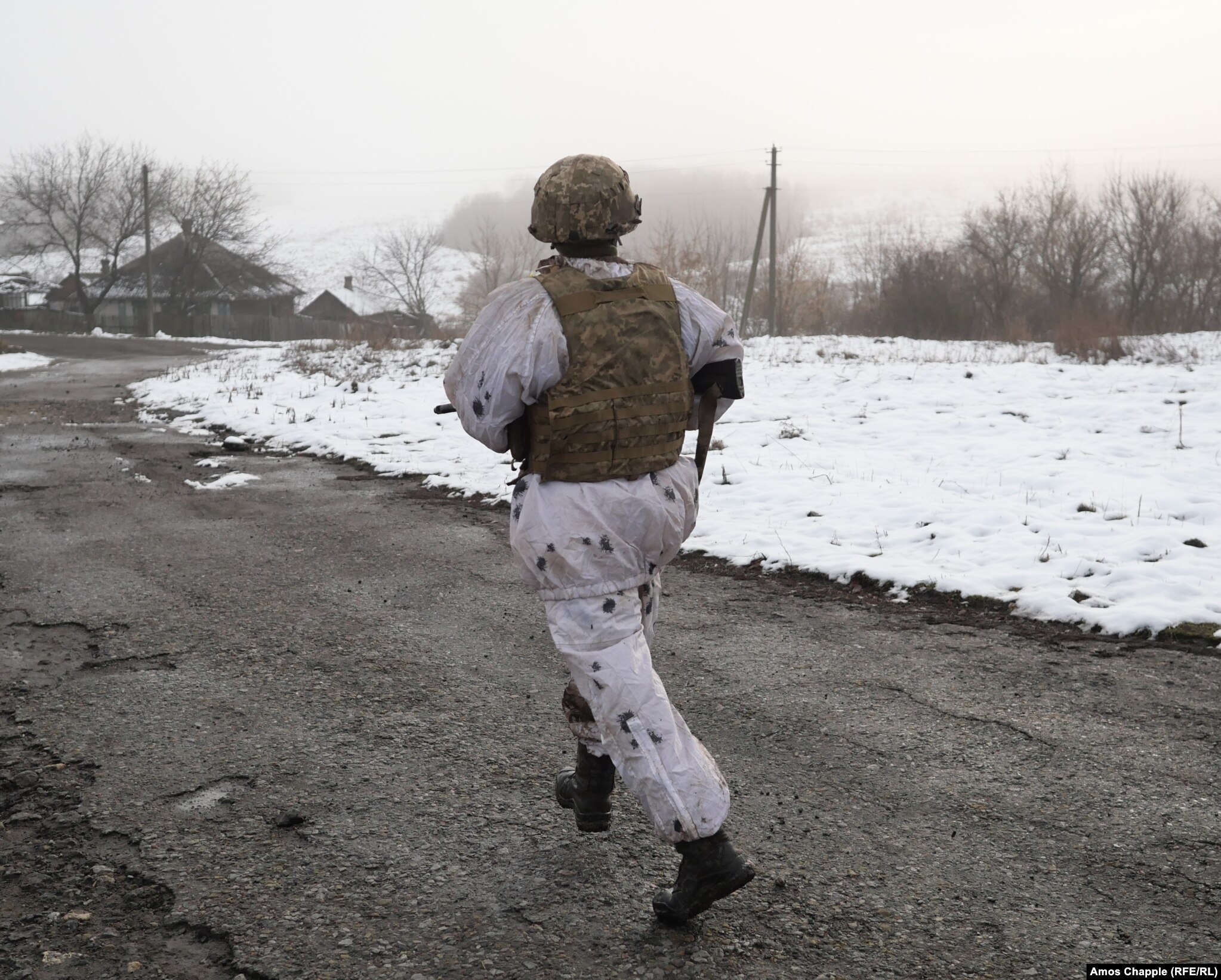 A Ukrainian soldier running while in view of nearby Russia-backed separatist positions in the Luhansk region on December 7.