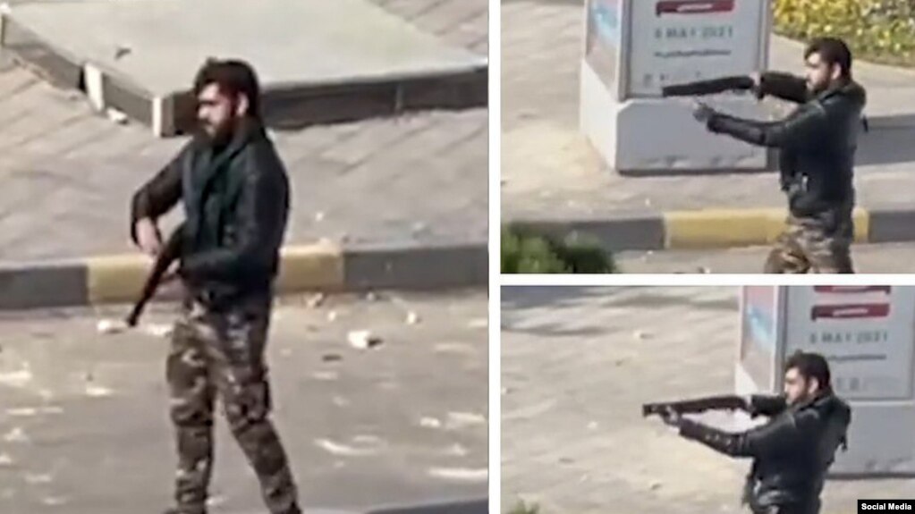 یکی از اعضای گردان‌های امنیتی امام علی بسیج اصفهان در حال تیراندازی با سلاح ساچمه‌زنی به سمت معترضان