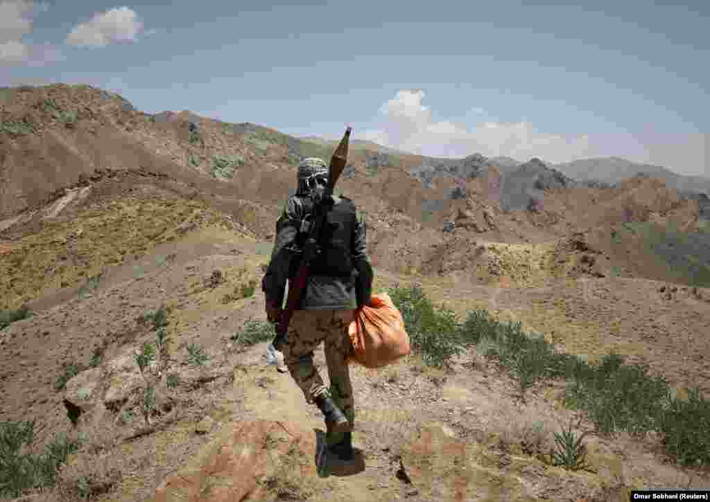 Боец-антиталибанец идет возле контрольно-пропускного пункта в районе Горбанд афганской провинции Парван