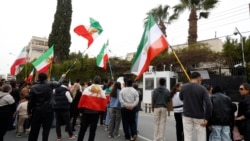 تجمع ایرانیان مقیم قبرس در مقابل سفارت ایران در نیکوزیا در حمایت از معترضان با پرچم‌های شیر و خورشید