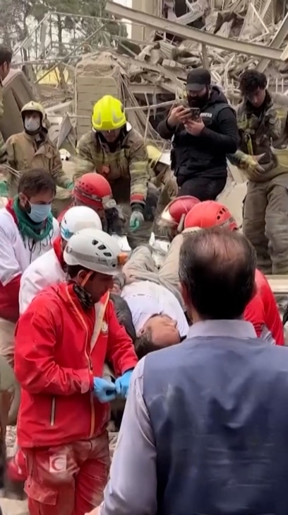 Các nhân viên cứu hộ Iran tìm kiếm những người sống sót bị mắc kẹt dưới đống đổ nát.