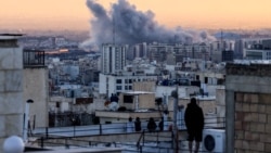 Një person qëndron në çatinë e një ndërtese duke parë një re tymi që ngrihet pas një sulmi në kryeqytetin iranian, Teheran, më 3 mars 2026.