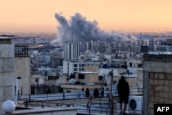 Әуе шабуылынан кейін көкке көтерілген түтінге алыстан қарап тұрған адам. Иран, Тегеран, 3 наурыз, 2026 жыл.