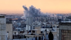 فردی، بر بام ساختمانی، به ستون دود برخاسته پس از حمله به تهران در روز سه‌شنبه نگاه می‌کند