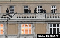 Zyrtarë të armatosur policorë shihen në ballkonin e universitetit.