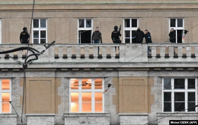 Zyrtarë të armatosur policorë shihen në ballkonin e universitetit.