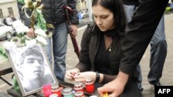 Students light candles near a portait of fellow student Ihor Indyl in Lviv in June.
