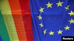 Un steag al Uniunii Europene este afișat alături de un steag Curcubeu în timpul paradei anuale Pride London din Londra.