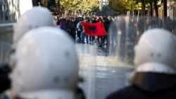 Demonstruesit shfaqin një flamur shqiptar para policëve të pajisur me mjete kundër trazirave, gjatë një proteste antiqeveritare nga studentët në Tiranë, Shqipëri, më 16 tetor 2026.