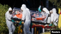Испанские медработники переносят одного из двух миссионеров, заразившихся Эболой в Африке. Мадрид, август 2014 года. 