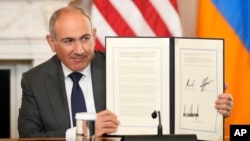 Armenian Prime Minister Nikol Pashinian holds a signed trilateral declaratoin during a ceremony with Azerbaijani President Ilham Aliyev and U.S. President Donald Trump at the White House, Washington, August 8, 2025.