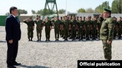 Kyrgyz President Sooronbai Jeenbekov (left) with members of the country's border guards (file photo)