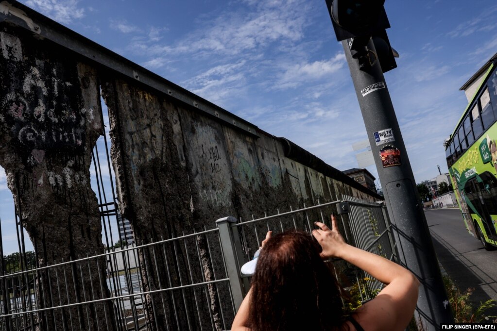 Një vizitore duke fotografuar një pjesë të mbetur të Murit të Berlinit, në vendin përkujtimor "Topografia e terrorit", në kryeqytetin e Gjermanisë. (12 gusht)