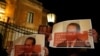 Protestors hold up posters showing Pilatus Bank chairman Ali Sadr Hashemi Nejad while calling for the resignation of Malta's police commissioner, outside police headquarters in Floriana, March 21, 2018