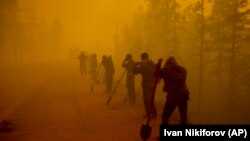 Volunteers pause while working at the scene of a forest fire west of Yakutsk on August 7.