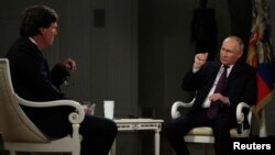 Америкалык журналист Такер Карлсон Орусиянын президенти Валдимир Путинден интервью алып жатат.
