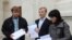 Мікалай Дзямідзенка, Віталь Рымашэўскі і Наста Палажанка паказваюць стосы лістоў з подпісамі.