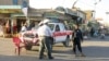 Afghan security officials stand guard near the site of a bomb blast in Kandahar on May 26.