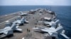 US Navy sailors work on the flight deck of the aircraft carrier USS George Washington as it transits the Arabian Sea near the Strait of Hormuz on August 20. 
