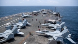 US Navy sailors work on the flight deck of the aircraft carrier USS George Washington as it transits the Arabian Sea near the Strait of Hormuz on August 20. 