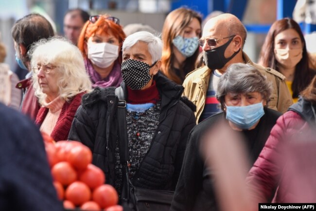 Njerëzit në tregun më të madh të hapur në Sofje, kanë vendosur maska të fytyrës teksa kanë dalë që të blejnë gjëra ushqimore. (AFP/Nikolay Doychinov)