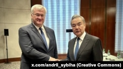 Министр иностранных дел Украины Андрей Сибига и глава МИД Китая Ван И во время встречи на полях Мюнхенской конференции в Германии
