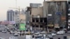Vehicles drive past a burnt out building destroyed during public protests in the Iranian capital Tehran on January 19, 2026.