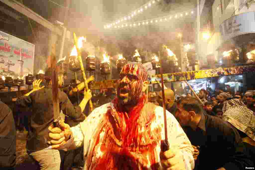 An Iraqi Shi&#39;ite Muslim man gashes his forehead with a sword before the religious festival of Ashura in Najaf on November 11. (Reuters/Alaa Al-Marjani)