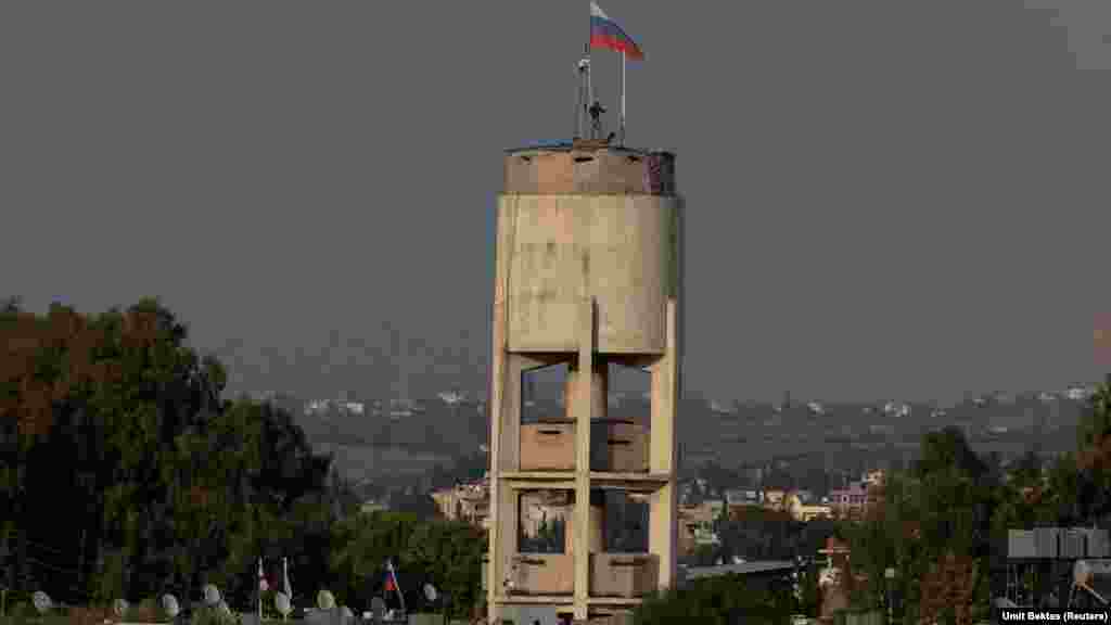 Ruski vojnici postavljaju nešto što izgleda kao nadzorni sistem na vrhu vodotornja unutar baze Hmeimim. Pored ovog očiglednog CCTV sistema, koji je Bektas snimio dok se gradio, kaže da postoji i &quot;nadzorni sistem u zraku, poput cepelina iznad vojne baze za nadgledanje okoline.&quot;