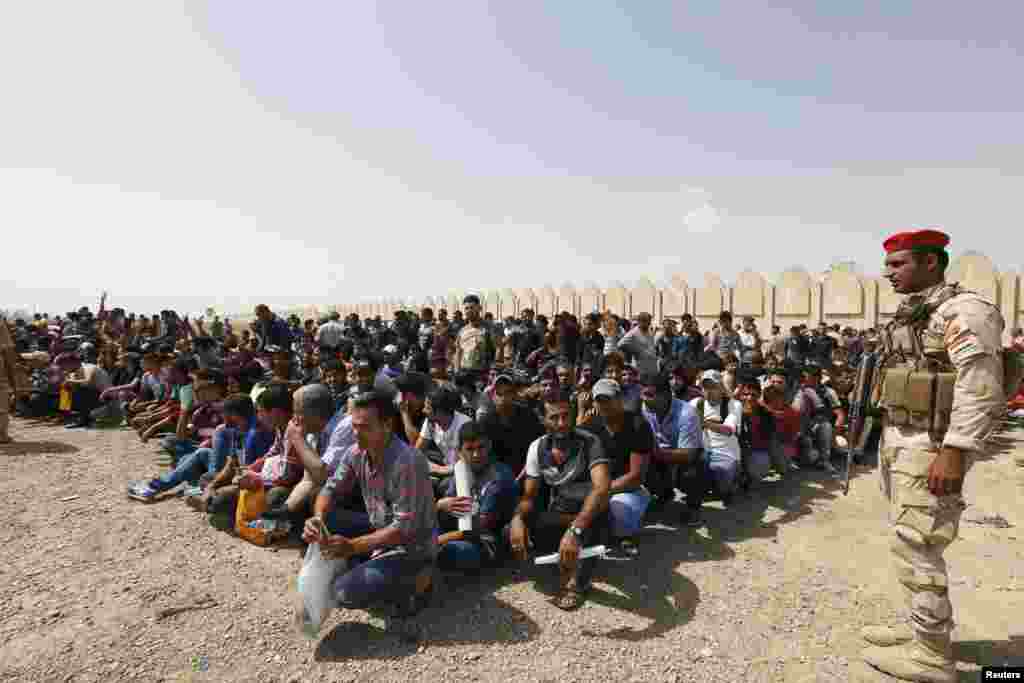 Volunteers waiting to join the Iraqi Army to fight against predominantly Sunni militants, who have taken over Mosul and other northern provinces, gather before boarding army trucks in Baghdad on June 13. (Reuters)