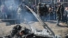 Indian soldiers and Kashmiri onlookers stand near the remains of an Indian Air Force aircraft after it crashed in Budgam district on February 27.