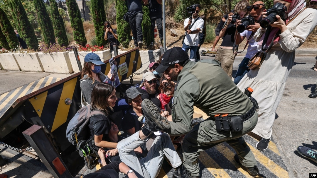 Un membru al forțelor de securitate israeliene încearcă să disperseze un protest anti-război organizat de activiști de stânga israelieni, în fața consulatului britanic la Ierusalim, pe 16 august 2024.