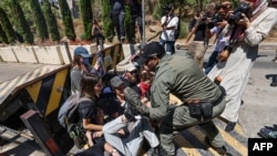 Un membru al forțelor de securitate israeliene încearcă să disperseze un protest anti-război organizat de activiști de stânga israelieni, în fața consulatului britanic la Ierusalim, pe 16 august 2024.