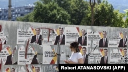 Një grua kalon pranë posterëve të liderit të partisë opozitare, VMRO-DPMNE, Hristijan Miskoski, Shkup 2020.