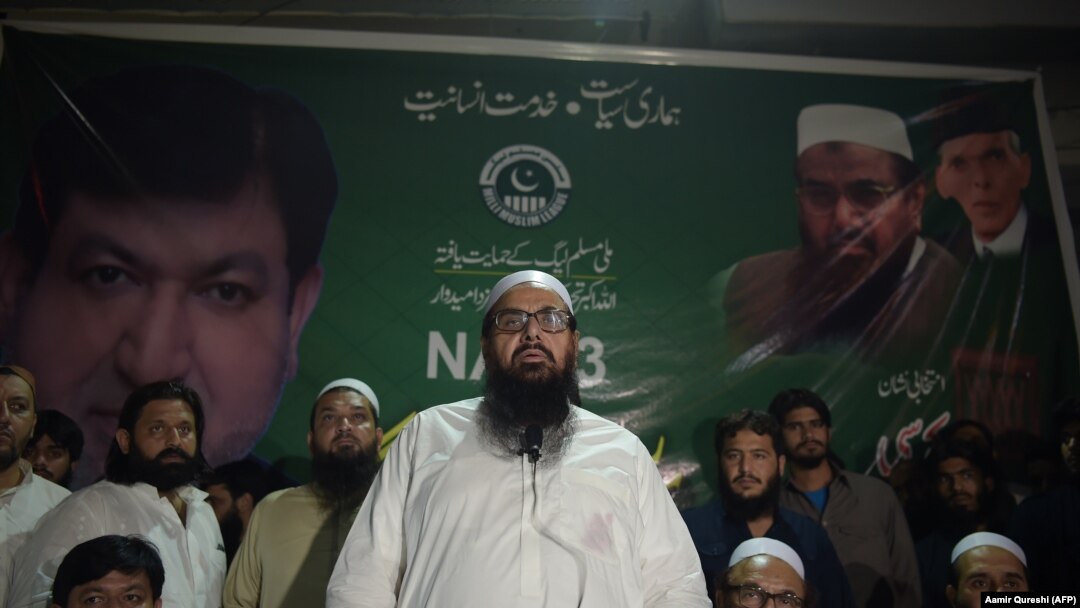 FILE: The head of Pakistani militant organziation Jamaat-ud-Dawa (JuD) Hafiz Saaed (C) along with his newly formed political party Allah-o-Akbar Tehreek nominated candidate Chaudhry Saeed Ahmed (L), speaks to supporters in June.
