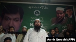 FILE: The head of Pakistani militant organziation Jamaat-ud-Dawa (JuD) Hafiz Saaed (C) along with his newly formed political party Allah-o-Akbar Tehreek nominated candidate Chaudhry Saeed Ahmed (L), speaks to supporters in June.