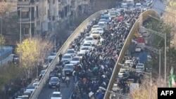 Comercianți pe un pod din Teheran, în timpul unei demonstrații din 29 decembrie față de condițiile economice și devalorizarea monedei iraniene. Unii comercianți din Teheran și-au închis magazinele pe 29 decembrie, în semn de protest față de dificultățile economice.