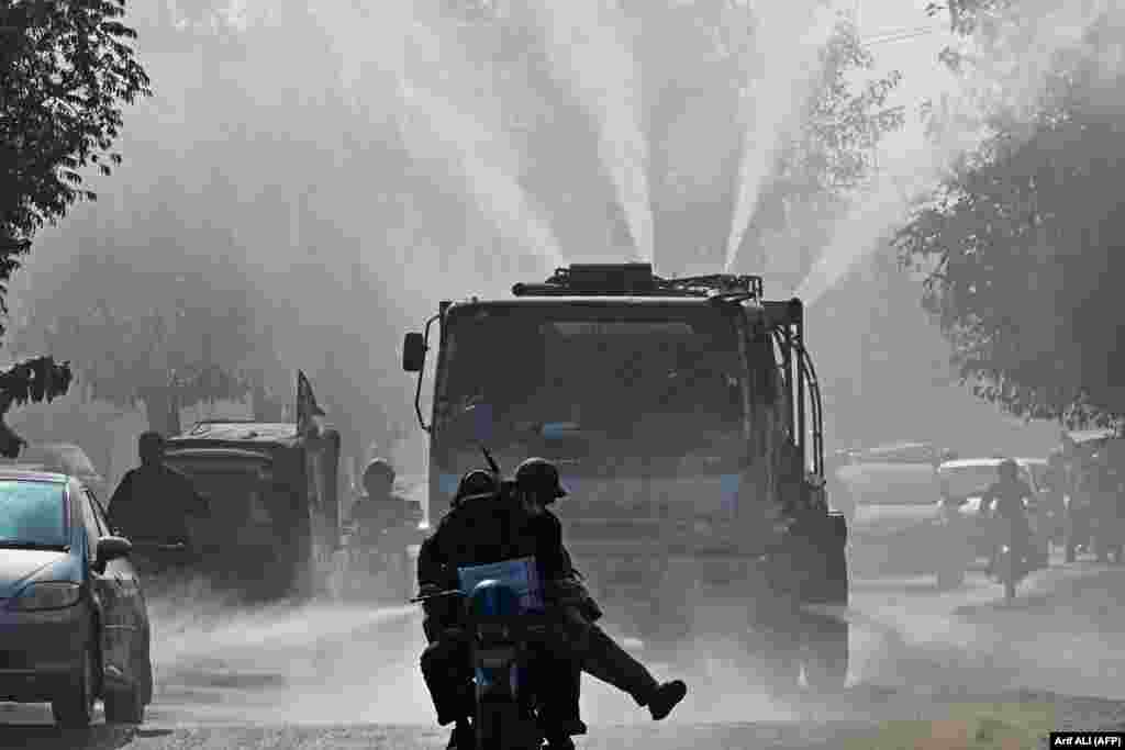 A Water and Sanitation Agency (WASA) vehicle sprays water using an anti-smog gun to fight air pollution amid heavy smog in Lahore, Pakistan.