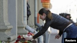 A woman lays flowers near the entrance to the Oktyabrskaya metro station in Minsk, where 15 people were killed in an explosion on April 11. 